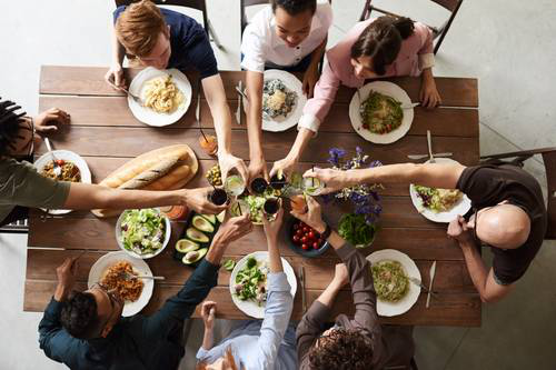 Friends making a toast around a wooden table